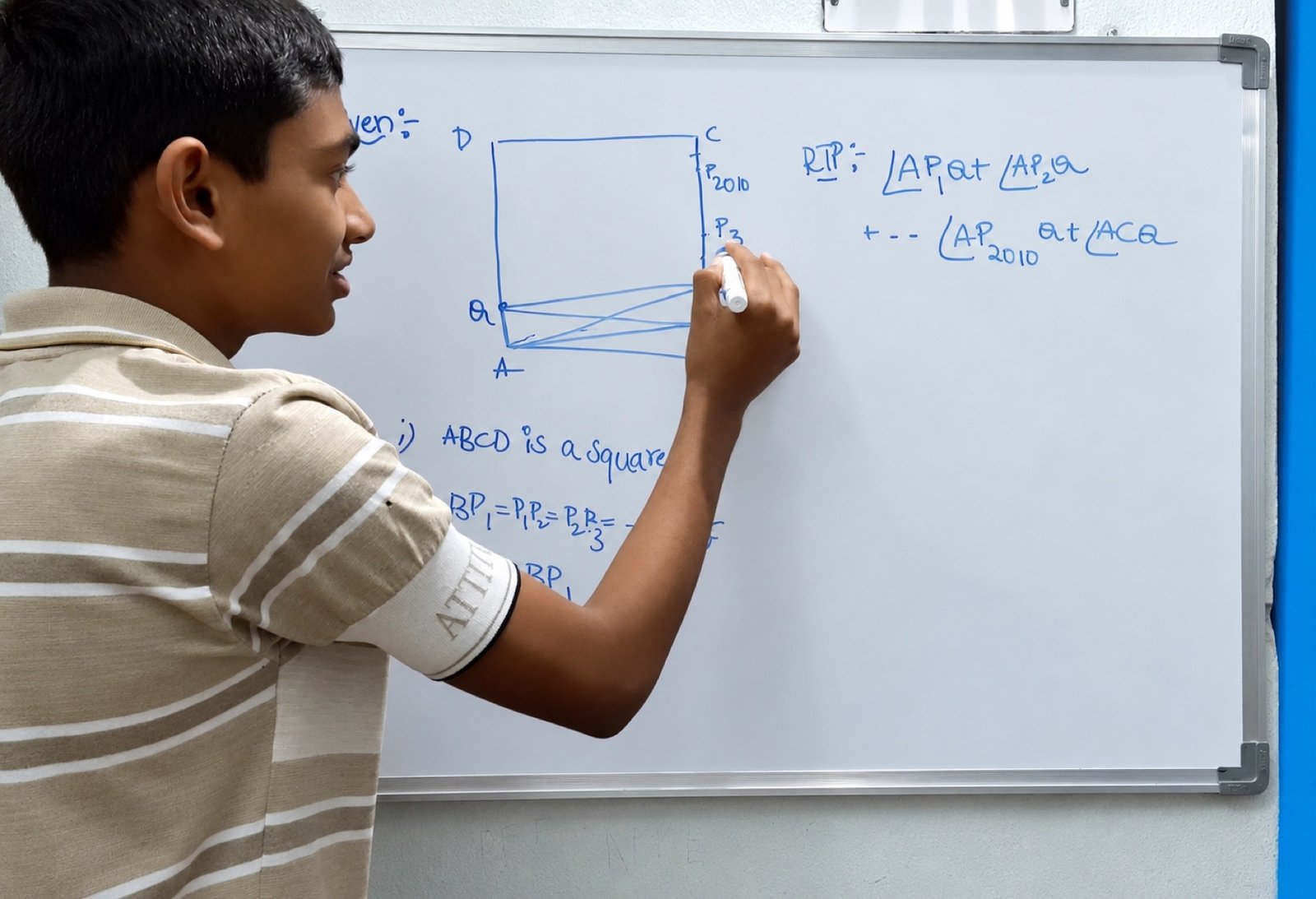 A younger Chandan Mettu explaining a geometry problem on a whiteboard
